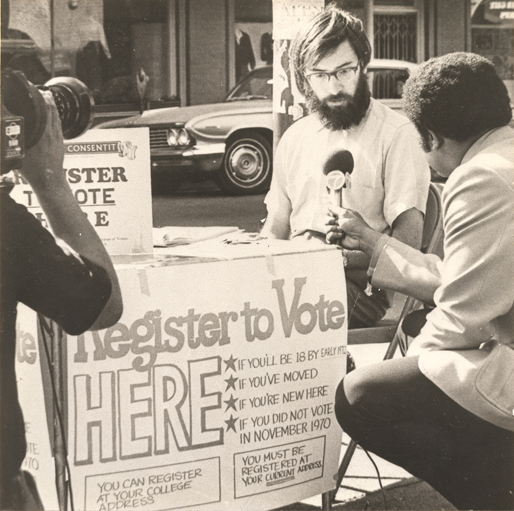 Picture of David Mundstock registering voters and doing a press interview