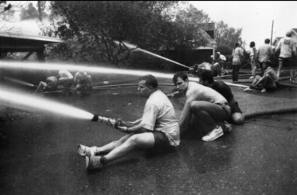 Picture of men holding fire hoses on fire